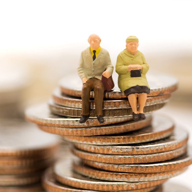 figurines of elderly couple sitting on coins